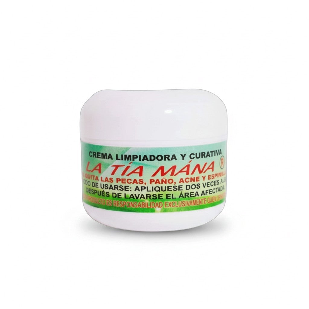 Tarro blanco con tapa blanca de Crema Limpiadora y Curativa La Tía Mana, con etiqueta verde y roja que indica su uso para pecas, paño, acné y espinillas, sobre fondo blanco.